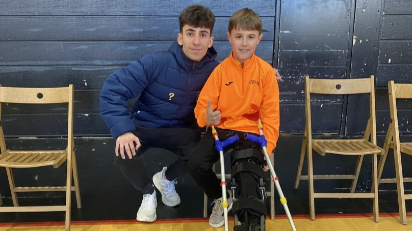 El youtuber solidario y futbolista de la Selección Española de Creadores Sxgarra junto a un joven jugador lesionado del CET10 Futsal durante su visita al club para dar apoyo moral a la cantera.
